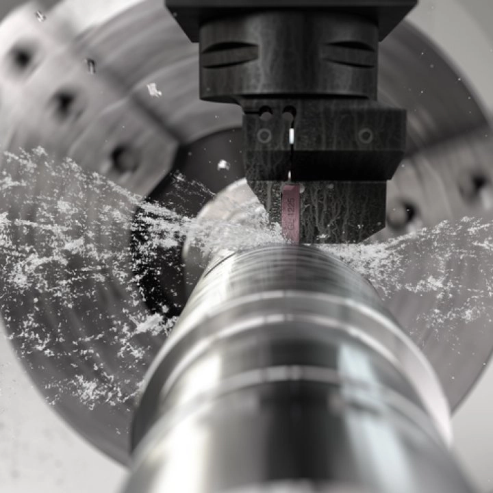 Sandvik Coromant CoroCut 2 verktøy i bruk ved avstikking av metallstang med kjølevæske.