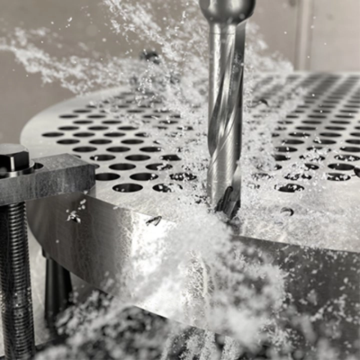 Sandvik Coromant bor lager hull i metallplate med kjølevæske under metallbearbeiding